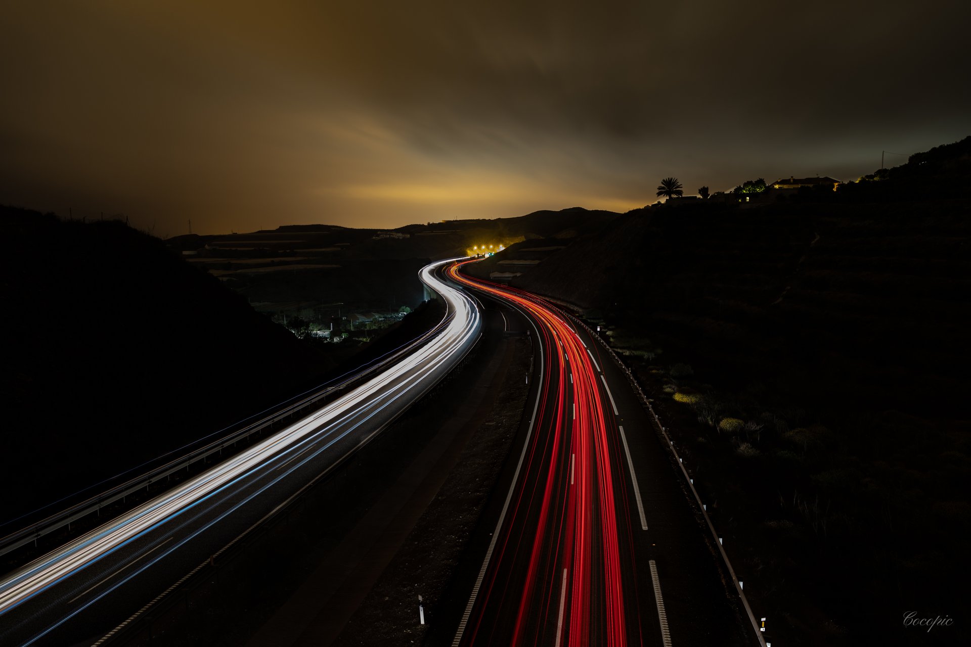 Trazos de luz de vehículos en carretera nocturna, larga exposición en la Costa del Sol